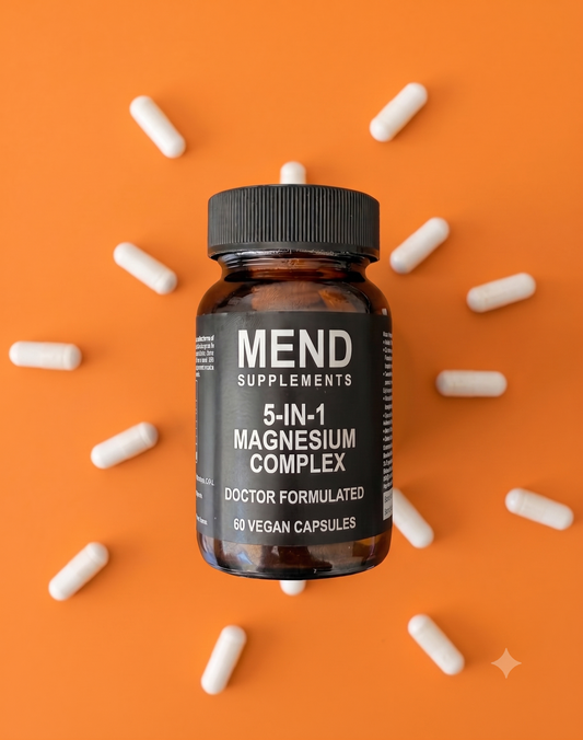 Mend Supplements 5-in-1 Magnesium Complex bottle, 60 vegan capsules, on an orange background surrounded by white capsules